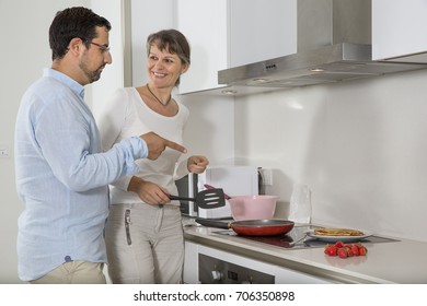 Couple Enjoying Making Pancakes In A Bright City Apartment Kitchen