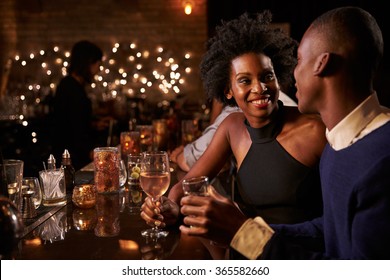 Couple Enjoying Night Out At Cocktail Bar - Powered by Shutterstock