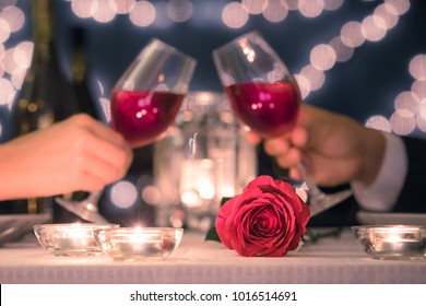 Couple Enjoying Romantic Candle Light Dinner.  Focus On Rose.  