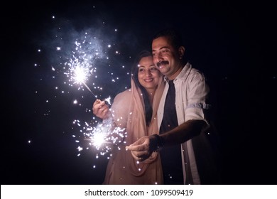 A couple enjoying the
sparkle firework as part of the celebration of a festival