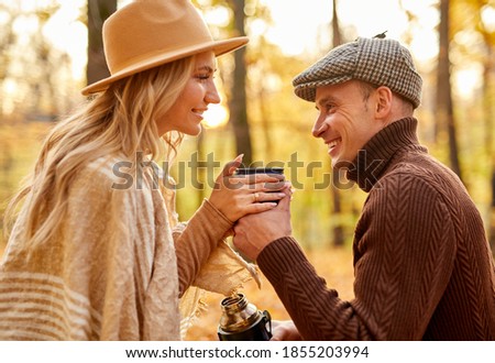 couple enjoying tea outdoors in the park, caucasian married man and woman have romantic time. side view
