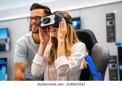 Couple enjoying with VR goggles at tech store. Shopping virtual reality people concept