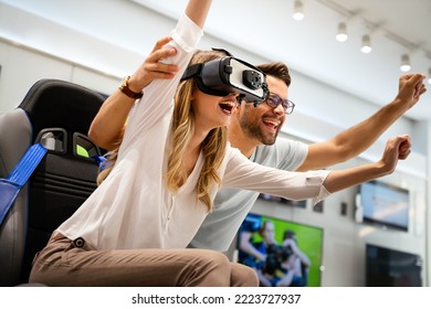 Couple Enjoying With VR Goggles At Tech Store. Shopping Virtual Reality People Concept