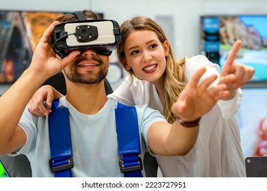 Couple Enjoying With VR Goggles At Tech Store. Shopping Virtual Reality People Concept