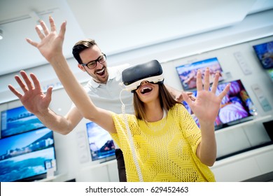 Couple Enjoying With VR Goggles At Tech Store. Shopping Couple Having Fun At Marketplace.