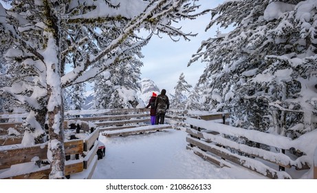 A couple enjoys snowy views from the trail on top of Sulphur Mountain in Banff, Alberta
