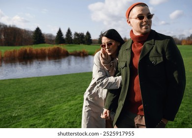 A couple enjoys a warm embrace by a serene lakeside in a beautiful autumn landscape. - Powered by Shutterstock