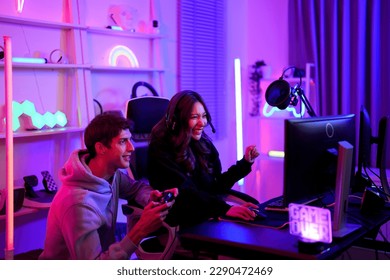 Couple e-sport gamer playing and helping clear stage challenge with happy enjoy feeling together in entertainment room - Powered by Shutterstock