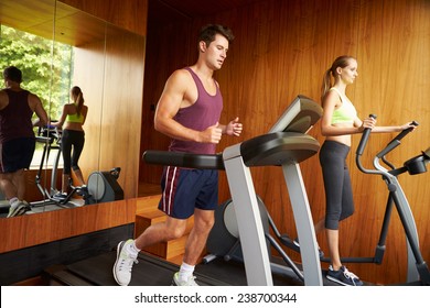 Couple Exercising Together In Home Gym