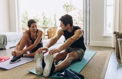 Couple Exercising Together. Man And Woman In Sports Wear Doing Workout At Home.