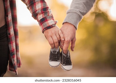 couple expecting a baby hands and his shoes - Powered by Shutterstock