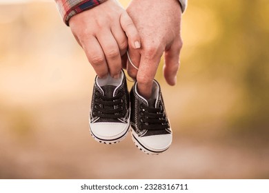 couple expecting a baby hands and his shoes - Powered by Shutterstock