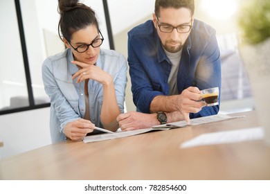 Couple with eyeglasses reading newspaper at home - Powered by Shutterstock