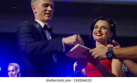 Couple Of Famous Actors Giving Autographs On Red Carpet Of Celebrity Event