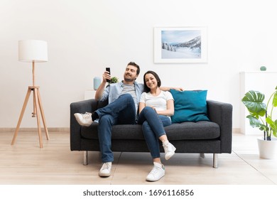Couple feeling happy and spending time at home - Shutterstock ID 1696116856