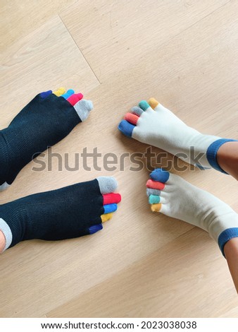 Couple feet in colourful socks on the wooden floor.