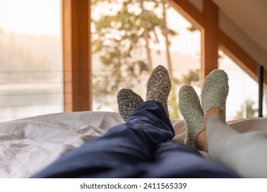 Couple feet relax in bed at home with cozy warm socks on  - Powered by Shutterstock