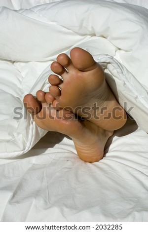 A couple of feet sticking out of a feather duvet
