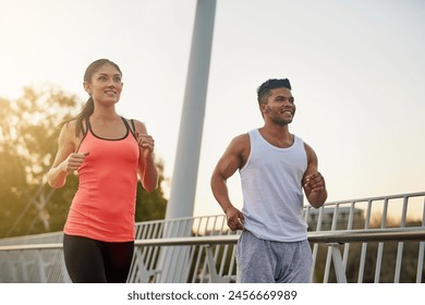 Couple, fitness and smile running outdoor for exercise, workout or cardio routine together on bridge. Happy, man and woman training or fast walking on road for strength, wellness and healthy bonding - Powered by Shutterstock