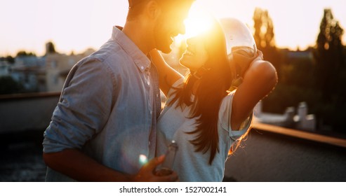 Couple flirting while having a drink on rooftop terrasse - Powered by Shutterstock