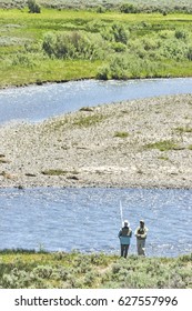 Couple Fly Fishing In The Lamar River, Yellowstone National Park.