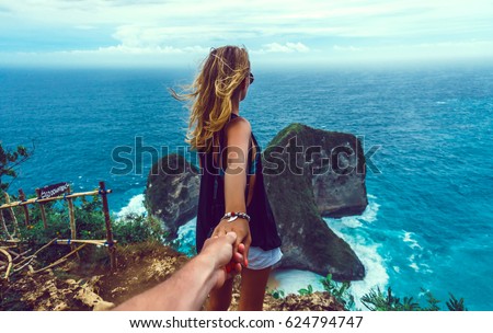 couple follow me in island, Woman wanting her man to follow her in vacation or honeymoon to beach by the ocean, love, hair wild, Indonesia Bali