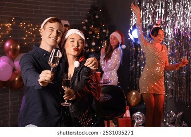 Couple of friends with champagne at New Year party - Powered by Shutterstock