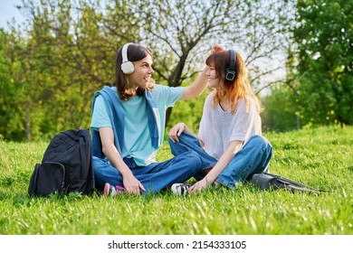 Couple Of Friends Guy And Girl 17, 18 Years Old Sitting On Grass