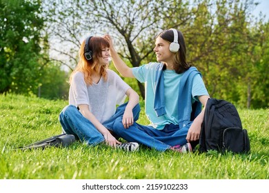 Couple Of Friends Guy And Girl 17, 18 Years Old Sitting On Grass