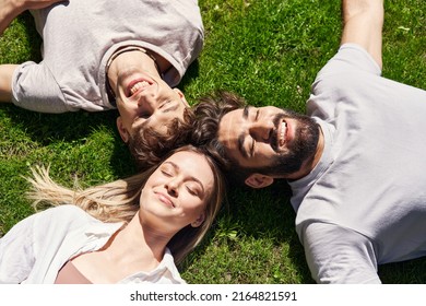 Couple Of Friends Lying On The Grass Relaxing In Sunlight 