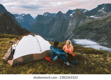 Couple friends in Norway mountains with camping tent gear on a romantic vacation. Man and woman embrace hiking adventure outdoor family healthy lifestyle - Powered by Shutterstock