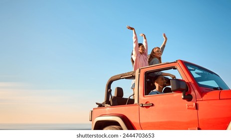 Couple With Friends On Vacation Driving Car On Road Trip Adventure To Beach Standing Up Through Roof - Powered by Shutterstock