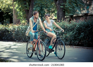 couple of friends young  man and woman riding bike in the city - Powered by Shutterstock