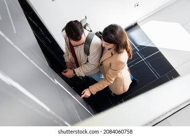 Couple In Front Of The Elevator Door.