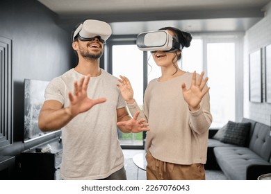 Couple, futuristic tech and virtual reality, metaverse and gaming with VR goggles, ux and cyber fantasy with online game. Digital, 3d with gamer man and woman at home, wifi and technology innovation - Powered by Shutterstock