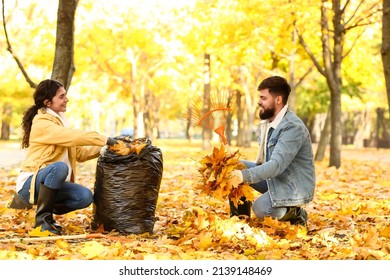 Couple gathering autumn leaves outdoors