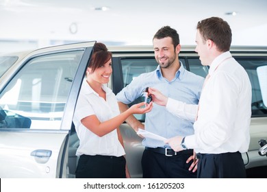 Couple Getting Car Keys From A Car Seller