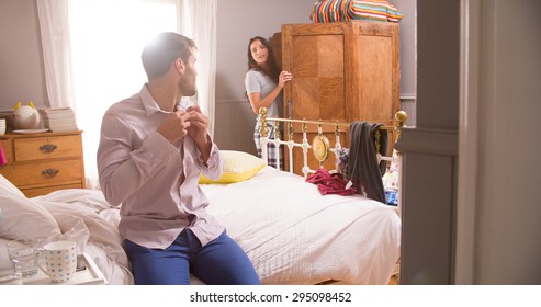 Couple Getting Dressed For Work In Bedroom