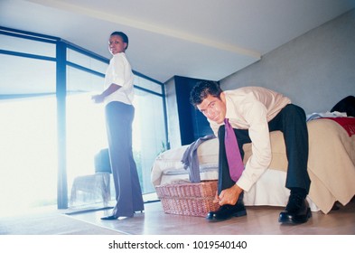 Couple Getting Ready For Work In Bedroom