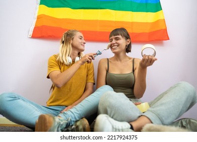 Couple Of Girls Sitting On The Floor After Painting Their New House Joking Together