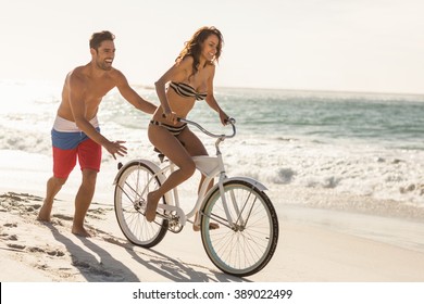 Couple Going On A Bike Ride On The Beach On A Sunny Day