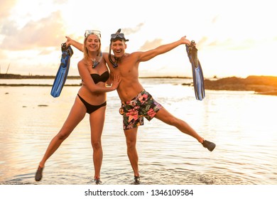 Couple Is Going To Swim And Snorkle On Hawaii Beach At The Sunset