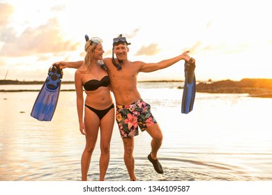 Couple Is Going To Swim And Snorkle On Hawaii Beach At The Sunset