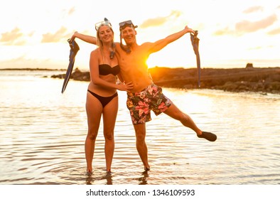 Couple Is Going To Swim And Snorkle On Hawaii Beach At The Sunset