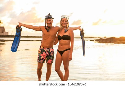 Couple Is Going To Swim And Snorkle On Hawaii Beach At The Sunset