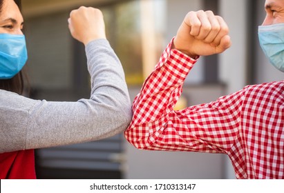 Couple Greeting With Elbows. Elbows Bump. Friends In Protective Medical Mask On His Face Greet Their Elbows In Quarantine. Elbow Bump. Coronavirus, Illness, Quarantine, Medical Mask, COVID-19.