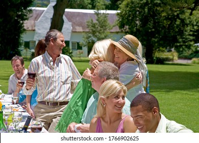 A Couple Greeting Guests At A Summer Garden Party