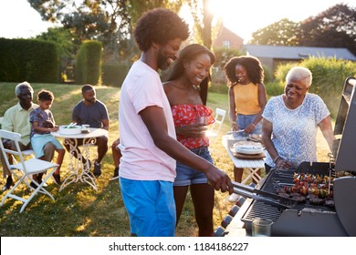 Couple Grilling At A Black Multi Generation Family Barbecue