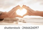 Couple, hands and heart by sunset with love on beach for honeymoon or vacation in summer with romantic gesture. Commitment, partnership and marriage with trust, promise and together in the Maldives.