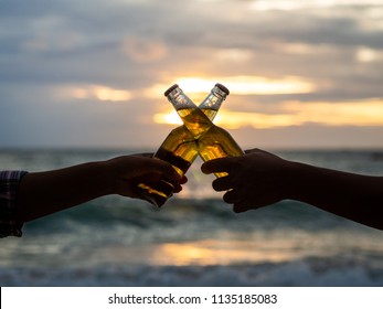 Couple hands holding beer bottles and clanging on the sunset beach. Party, Holiday, Summer, Friendship Concept. - Powered by Shutterstock